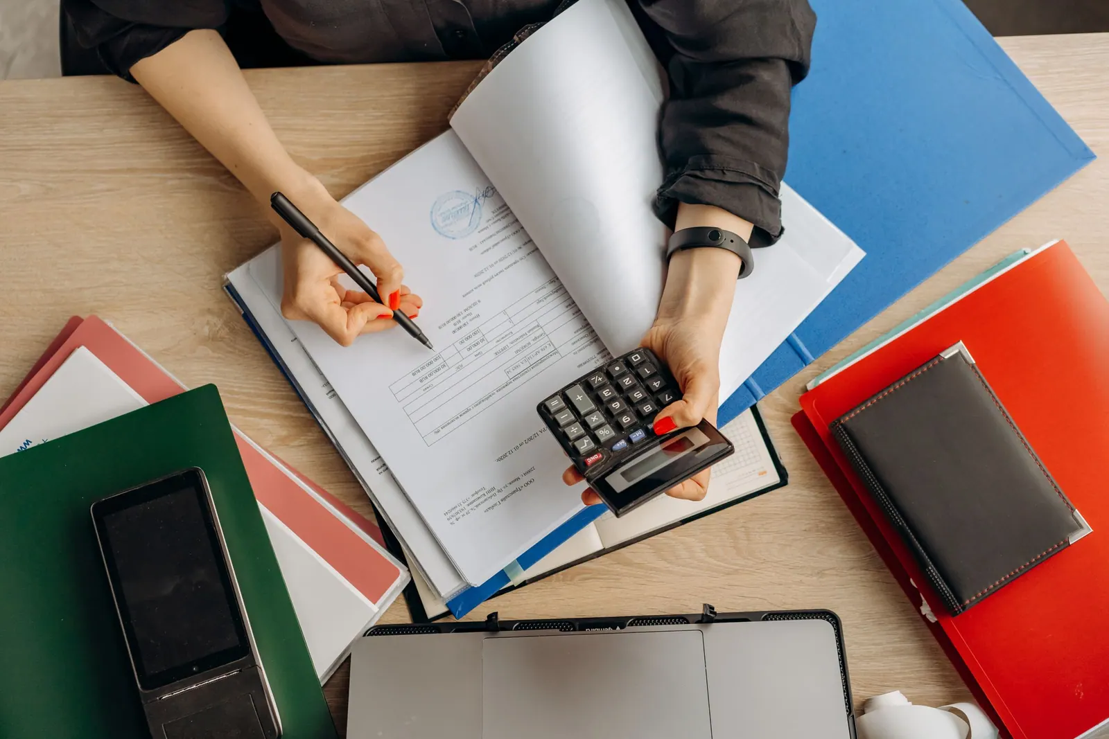 Bookkeeping at a desk with a calculator and folders
