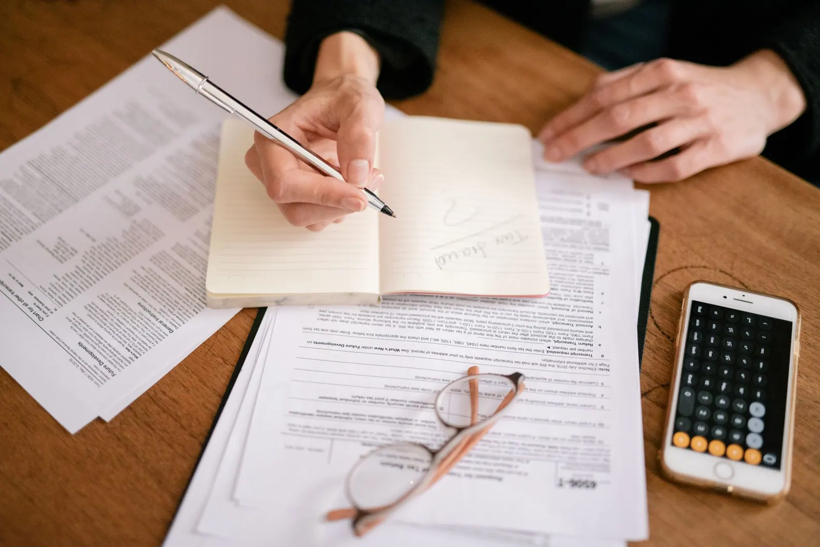 Tax forms, a notebook and a calculator on a desk